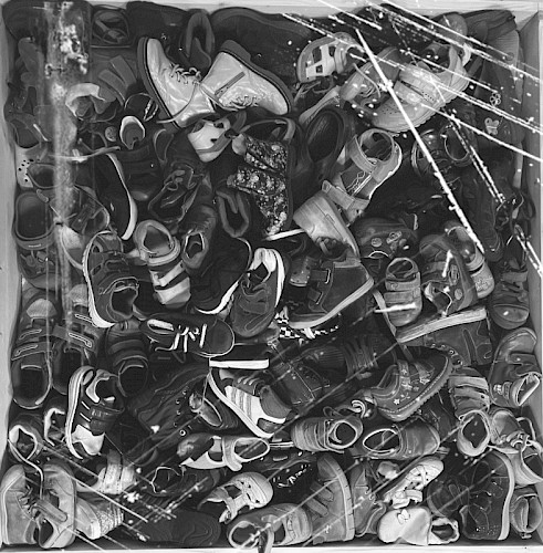 „Walk of Shame” partizipative Installation 2022, Ausschnitt - Kasten, gebrauchte Kinderschuhe, Sicherheitsglas. Muss im Bürgersteig ebenerdig eingelassen werden